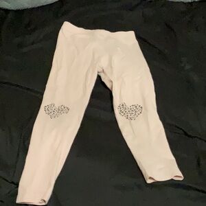 Little girl, pink leggings with cheetah print hearts on the knees